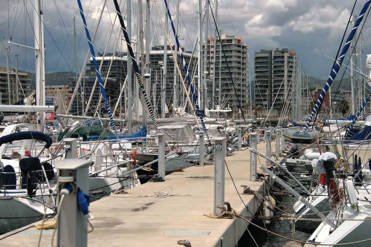 Embarcaciones amarradas en el Port de Badalona, con edificios del entorno de Gorg al fondo