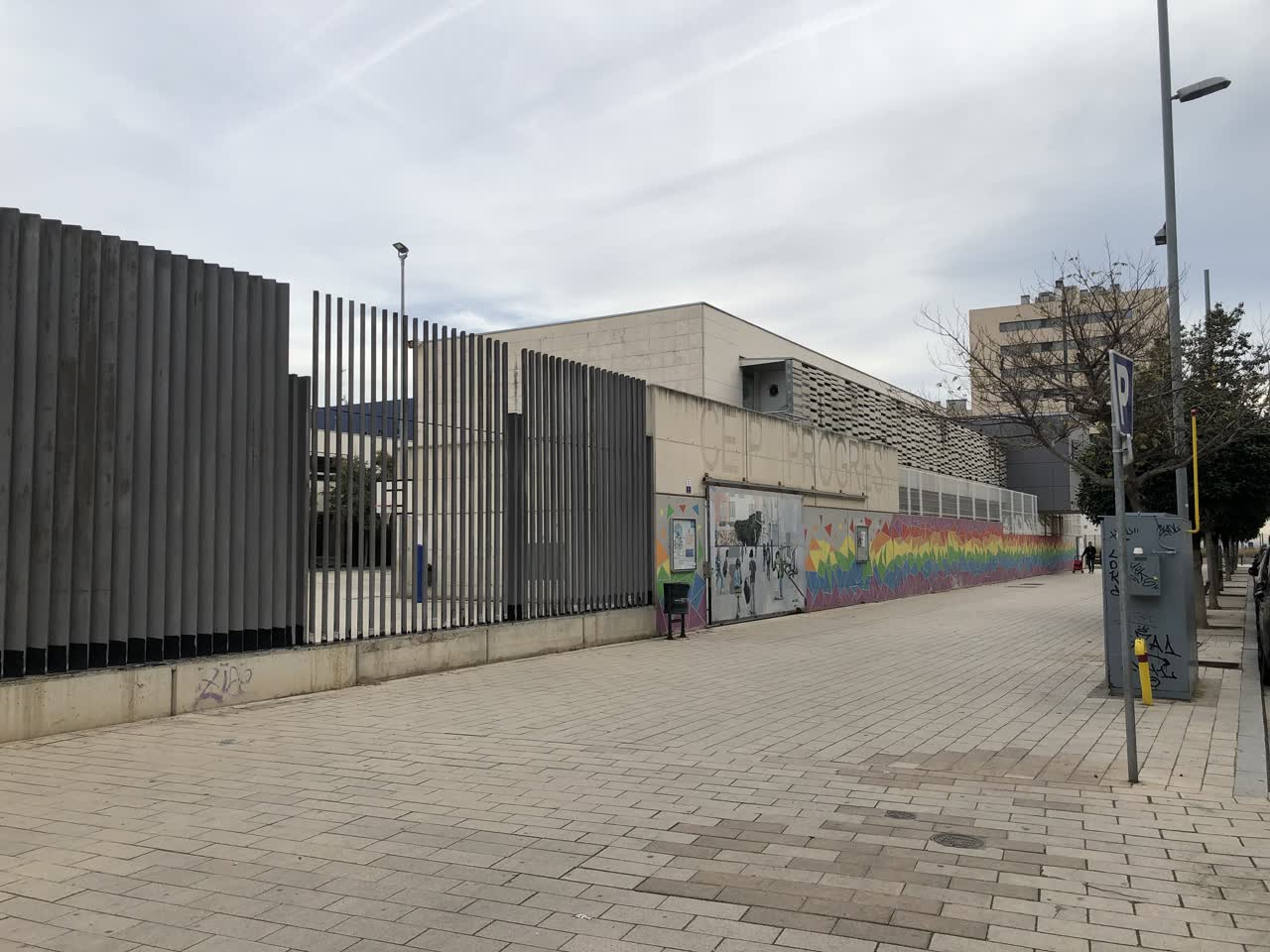 Fachada de la Escola Progrés en Badalona, junto a la calle y los edificios del entorno